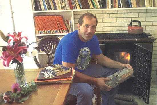 Dan Melcon, by his wood stove in White River Junction, VT, remains devoted to wood heat.